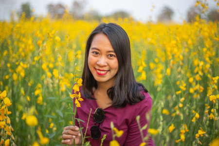 Young woman in a field of yellow flowersの写真素材