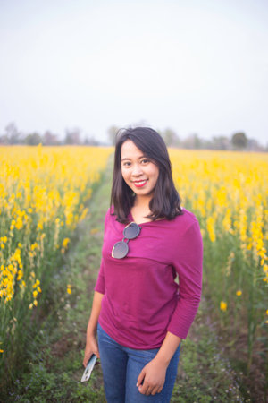 Young woman in a field of yellow flowersの写真素材