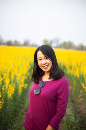 Young woman in a field of yellow flowersの写真素材
