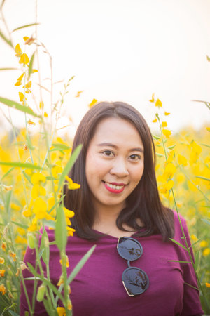 Young woman in a field of yellow flowersの写真素材