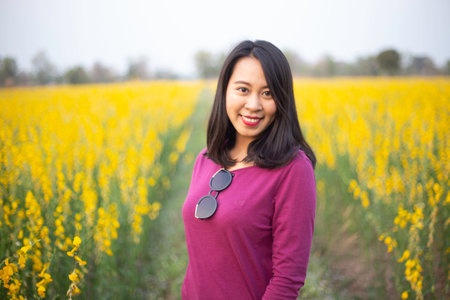 Young woman in a field of yellow flowersの写真素材