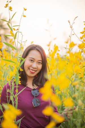 Young woman in a field of yellow flowersの写真素材
