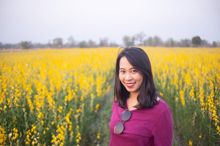 Young woman in a field of yellow flowersの写真素材