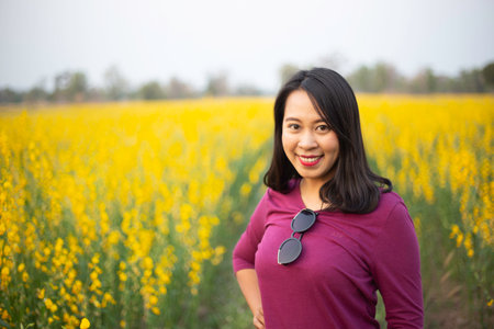 Young woman in a field of yellow flowersの写真素材