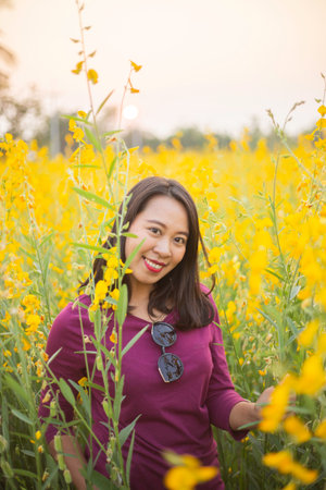 Young woman in a field of yellow flowersの写真素材