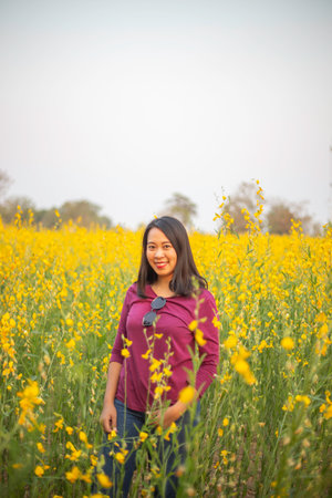 Young woman in a field of yellow flowersの写真素材
