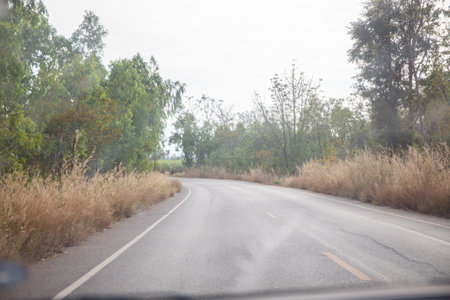 Mountain roads can vary greatly in size and complexity, from narrow dirt paths to multi-lane highways. They may be paved or unpaved, and may include features such as switchbacks, hairpin turns, and steep grades.の写真素材