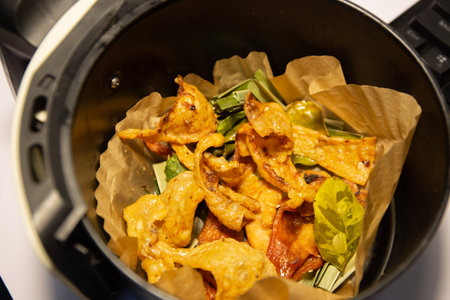 crispy chicken skin with fried kaffir lime leaves cooking in a black potの写真素材