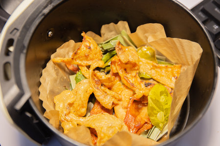 crispy chicken skin with fried kaffir lime leaves cooking in a black potの写真素材