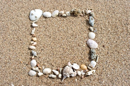 Seashell frame on sandの写真素材