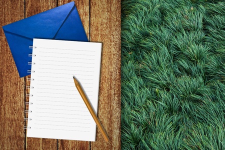 Notebook on wooden floor with green grass backgroundの写真素材