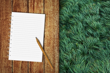 Notebook on wooden floor with green grassの写真素材