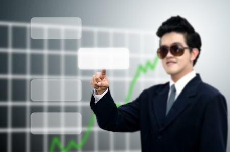 Asian businessman push the blank button with graph backgroundの写真素材