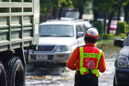 BANGKOK, THAILAND - NOV 7 : UNIDENTIFIED POLICEMAN WORKING IN WATER FLOOD ON NOV 7, 2011 IN KAMPHAENG PHET INTERSECTION, BANGKOK, THAILAND. THE BIG FLOOD IN BANGKOKのeditorial素材