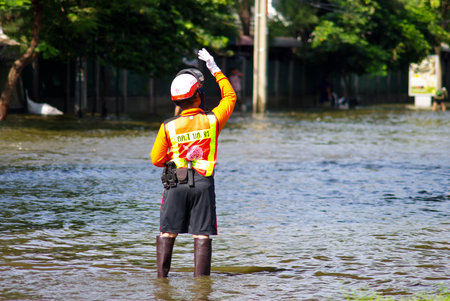 BANGKOK, THAILAND - NOV 7 : UNIDENTIFIED POLICEMAN WORKING IN WATER FLOOD ON NOV 7, 2011 IN KAMPHAENG PHET INTERSECTION, BANGKOK, THAILAND. THE BIG FLOOD IN BANGKOKのeditorial素材