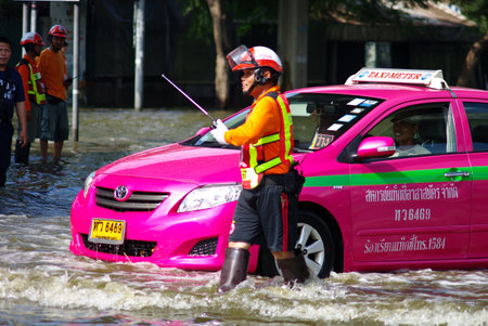 BANGKOK, THAILAND - NOV 7 : UNIDENTIFIED TRAFFIC POLICEMAN WORKING IN WATER FLOOD ON NOV 7 2011 IN KAMPHAENG PHET INTERSECTION, BANGKOK, THAILAND. THE BIG FLOOD IN BANGKOKのeditorial素材