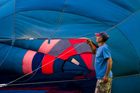 CHIANG MAI - NOV 26: Unidentified man fill hot air in balloon during Thailand balloon festival 2011 at Prince Royal college in Chiang mai, Thailand on Nov 26, 2011.のeditorial素材