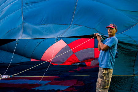 CHIANG MAI - NOV 26: Unidentified man fill hot air in balloon during Thailand balloon festival 2011 at Prince Royal college in Chiang mai, Thailand on Nov 26, 2011.のeditorial素材