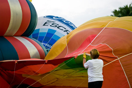 CHIANG MAI, THAILAND - NOV 26: Unidentified woman fill hot air in balloon during Thailand balloon festival 2011 at Prince Royal college in Chiangmai, Thailand on Nov 26, 2011.のeditorial素材