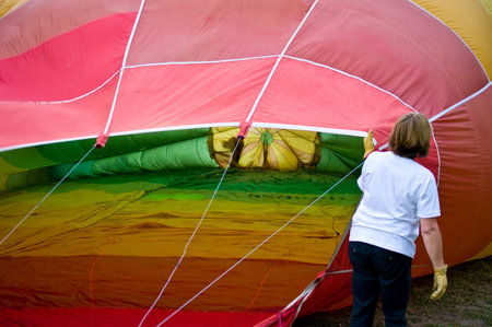 CHIANG MAI, THAILAND - NOV 26: Unidentified woman fill hot air in balloon during Thailand balloon festival 2011 at Prince Royal college in Chiangmai, Thailand on Nov 26, 2011.のeditorial素材