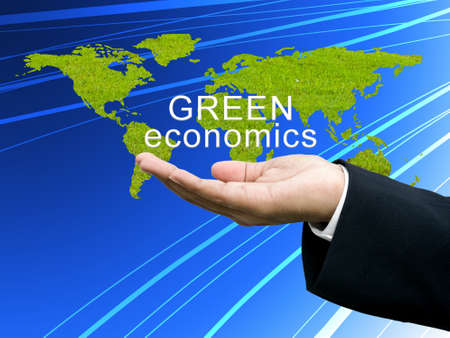 Green economics on businessman's handの写真素材
