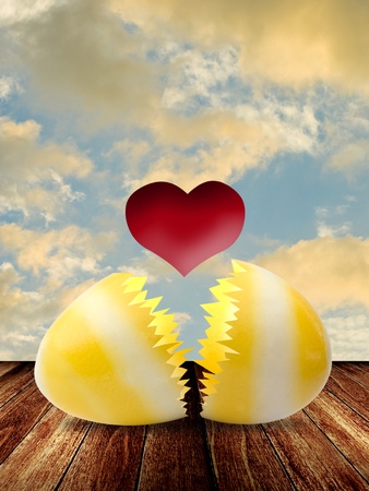 Red heart inside easter egg on wooden tableの写真素材