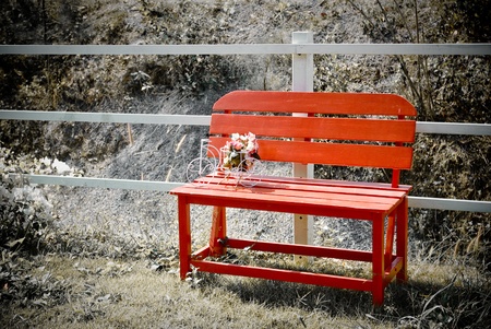 Red bench with bouquet in the garden, Retro styleの写真素材