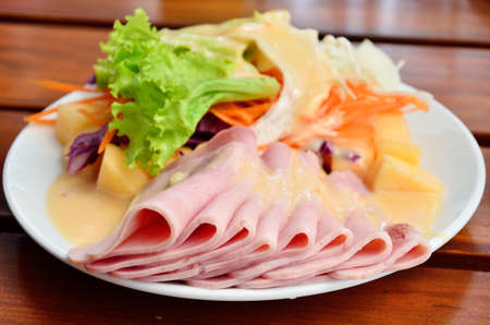 Ham with salad on wooden tableの写真素材