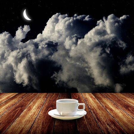 Hot coffee on wooden table with night sky の写真素材