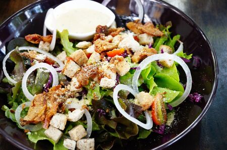 Salad with cream sauce in black dishの写真素材
