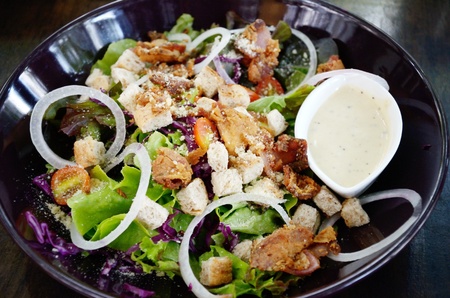 Salad with cream sauce in black dishの写真素材