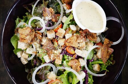Salad with cream sauce in black dishの写真素材