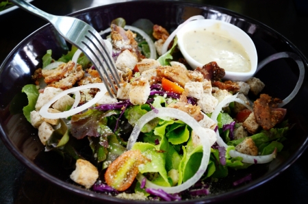 Salad with cream sauce in black dishの写真素材