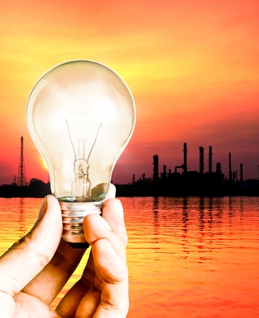 Hand hold the light bulb with oil refinery, Save power conceptの写真素材