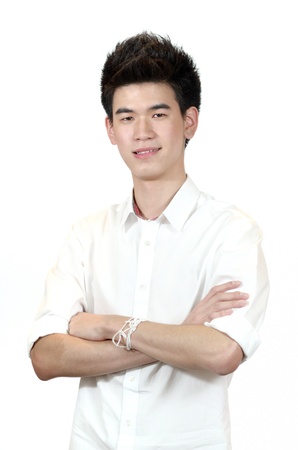 Portrait of a happy Asian teenage standing with arms crossed isolated against white backgroundの写真素材
