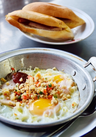 Fried egg with pork and sausage in hot pan, Breakfast in Thai styleの写真素材