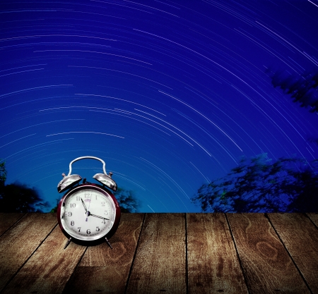 Alarm clock with star trails background  Long exposure conceptの写真素材
