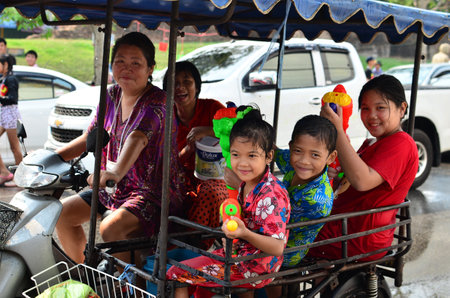 CHIANG MAI, THAILAND - APRIL 12 : Kid celebrating Songkran with family in the streets by throwing water at each other on 12 April 2013 in Chiang Mai, Thailandのeditorial素材