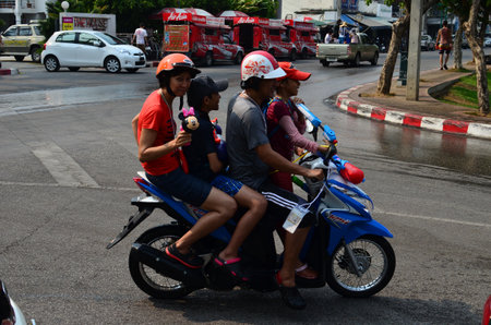 CHIANG MAI, THAILAND - APRIL 12 : Family with motorbike celebrating Songkran (Thai new year / water festival) in the streets by throwing water at each other on 12 April 2013 in Chiang Mai, Thailandのeditorial素材