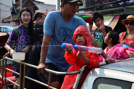 CHIANG MAI, THAILAND - APRIL 12 : Kid celebrating Songkran with family in the streets by throwing water at each other on 12 April 2013 in Chiang Mai, Thailandのeditorial素材
