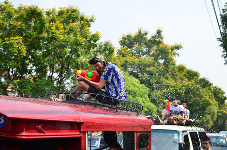 CHIANG MAI, THAILAND - APRIL 13 : Tourists sit on bus roof for celebrating Songkran (Thai new year / water festival) on 13 April 2013 in Chiang Mai, Thailandのeditorial素材