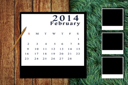 Calendar 2014 set with photo frame on wooden floor and grass backgroundの写真素材