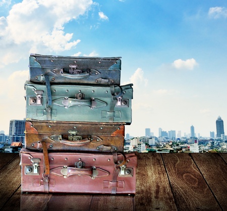 Vintage travel luggage on wooden wall with city view backgroundの写真素材