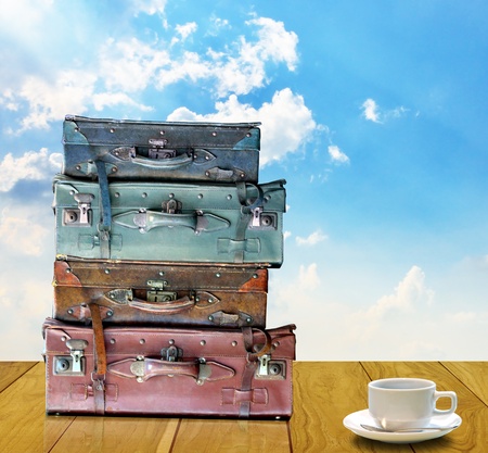 Ready for travel in morning concept, Old travel bag and coffee cup on wooden tableの写真素材