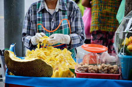BANGKOK, THAILAND - OCTOBER 2 : Unidentified woman sell jackfruit beside street on 2 October 2012 in Bangkok, Thailandのeditorial素材