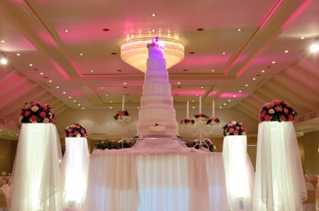 Wedding cake with rose flower decorate in ballroom の写真素材