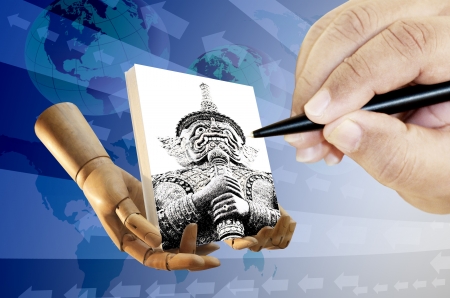 Human hand with pen drawing Thai giant on canvasの写真素材