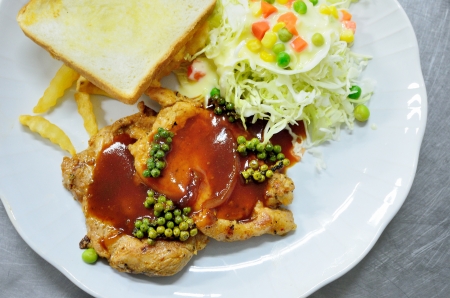 Pork pepper steak with bread and saladの写真素材