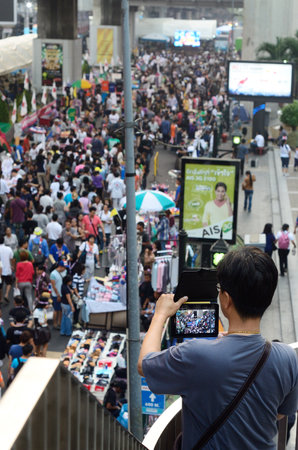 BANGKOK-JAN 26   Unidentified man take photo the protesters gather Patumwan intersection to anti government and ask to reform before election with のeditorial素材