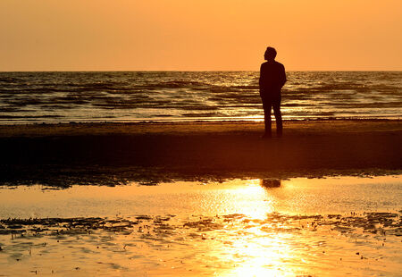 Silhouette man on beach with sunset sky background, Thailandの写真素材